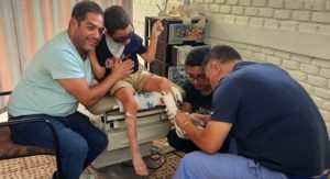 A young international patient named Christopher is cared for by health professionals.