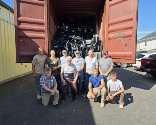 Hands of Hope volunteers loading wheelchairs into a shipping container bound for Guatemala